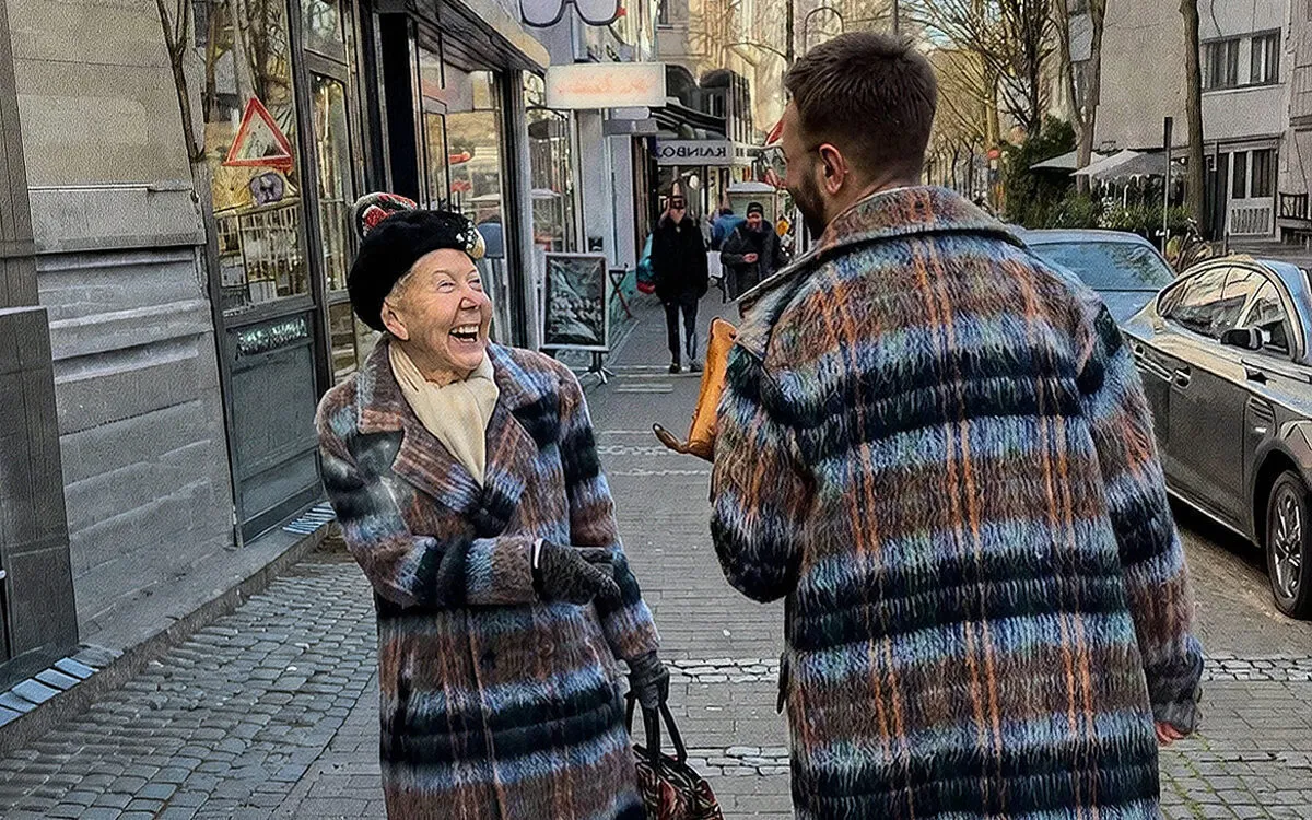 Man and woman smiling at each other when they realize they are wearing the same coat